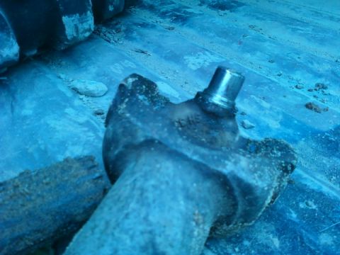 1990 Ford Bronco - A close-up view of a dirty driveshaft U-joint, showing a metal pin.