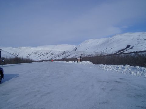 2009 Kenworth T800 - A truck is parked on the side of a road in a snowy mountain landscape.