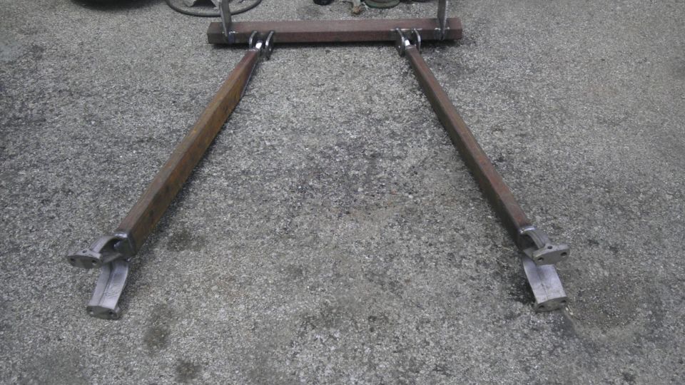 Custom A-arm suspension part made of welded steel bars on concrete