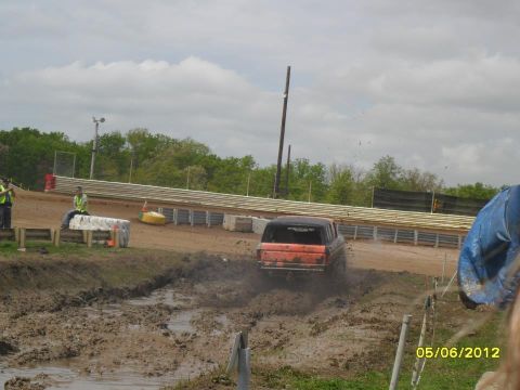 1978 Ford Bronco - A 1978 Ford Bronco navigates a muddy track, kicking up dirt and water.