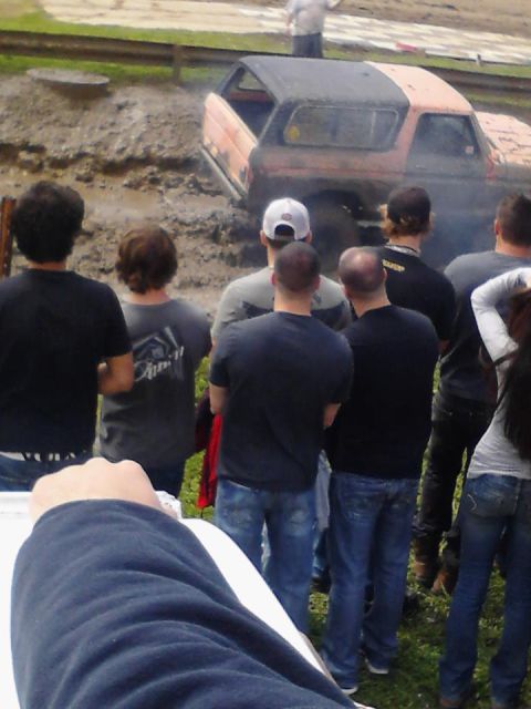1978 Ford Bronco - A crowd watches as a two-tone Ford Bronco attempts to navigate a muddy obstacle.