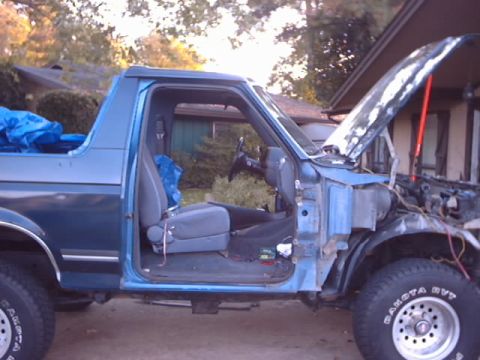 1990 Ford Bronco - This 1990 Ford Bronco is shown with its hood and driver's door open, indicating it is likely undergoing repairs or modifications.