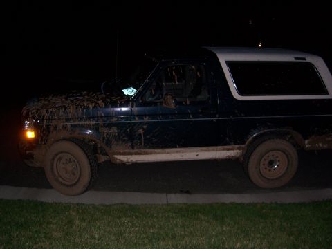 1992 Ford Bronco - Muddy 1992 Ford Bronco seen from the side at night.