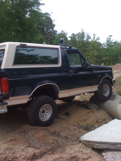 1992 Ford Bronco - This 1992 Ford Bronco is navigating an off-road course, with its tires positioned over large rocks.
