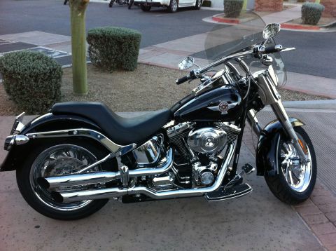 1978 Ford Bronco - A black Harley-Davidson motorcycle is parked on a paved surface, its chrome details and windshield.