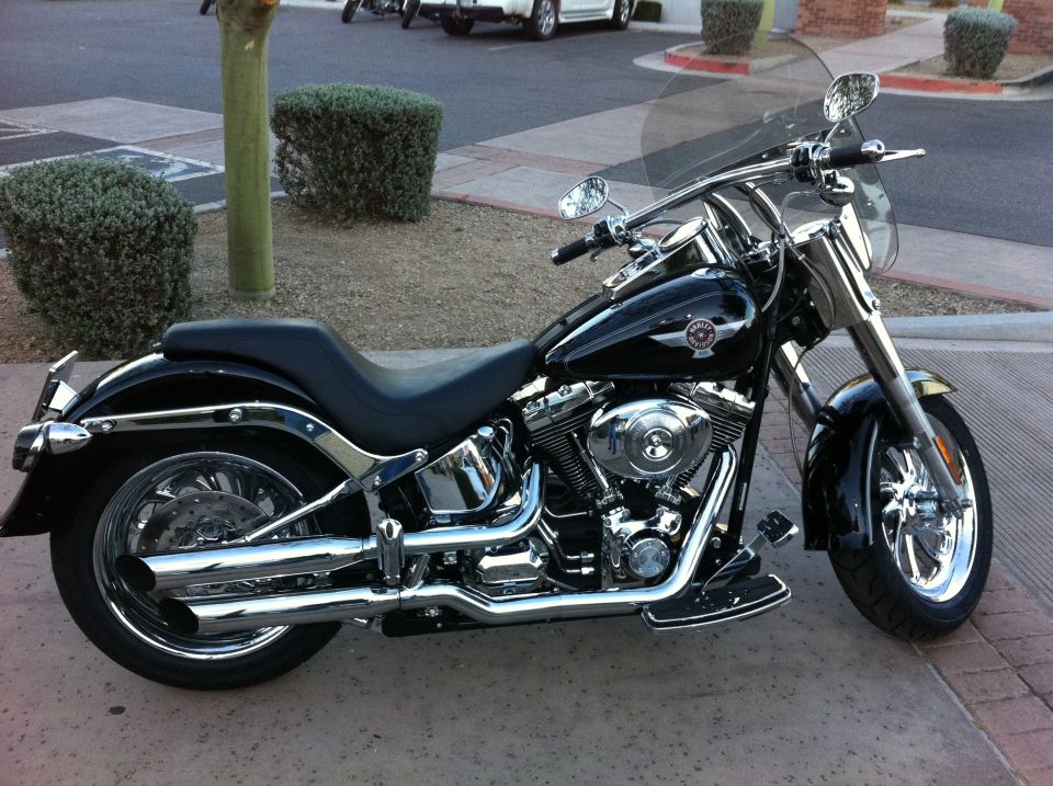 Black Harley-Davidson motorcycle side view with chrome accents and windshield