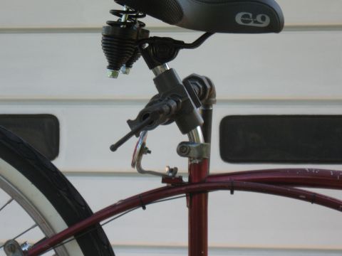 1994 Ford Bronco - Detail shot of a bicycle seat assembly and red frame tubing against a white garage door.