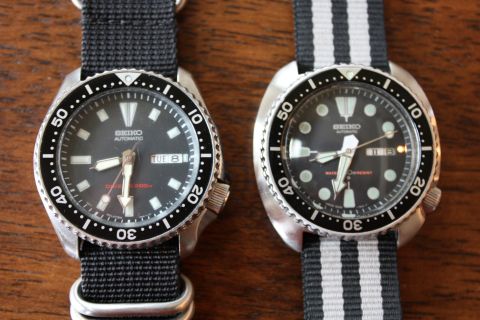 1986 Ford Bronco - Two Seiko automatic dive watches are displayed side-by-side on a wooden surface.