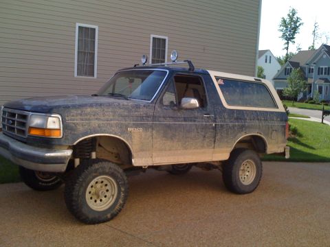 1992 Ford Bronco - This lifted 1992 Ford Bronco is covered in mud, suggesting it has seen off-road use.