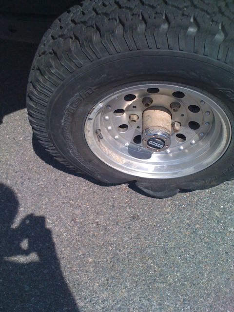 1992 Ford Bronco - Flat tire on a vehicle with a chrome rim and BFGoodrich tire.