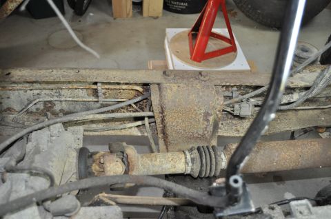1986 Ford Bronco - Undercarriage view shows extensive rust on the frame and drivetrain components.