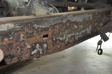 1986 Ford Bronco - Close-up of a heavily corroded vehicle frame, showing significant rust damage and pitting.
