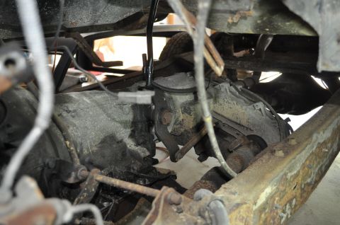 1986 Ford Bronco - Close-up of vehicle undercarriage components, including transmission and suspension parts.