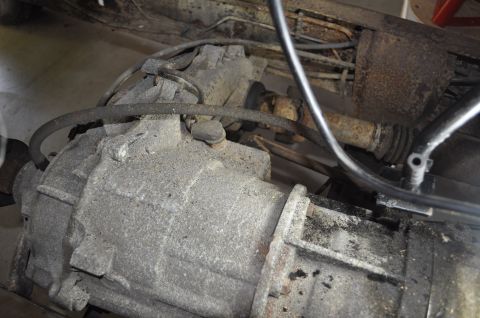 1986 Ford Bronco - Close-up view of a transmission and driveshaft assembly, likely from a vehicle undergoing repair or disassembly.