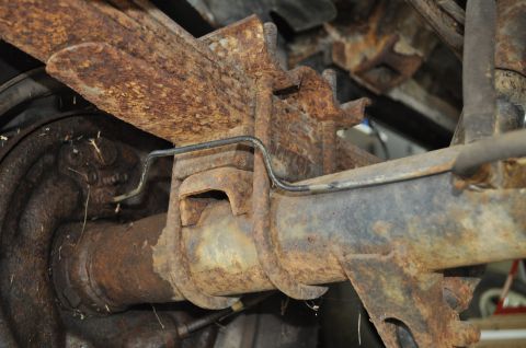 1986 Ford Bronco - The rear axle and suspension components are heavily rusted, showing significant wear and tear.