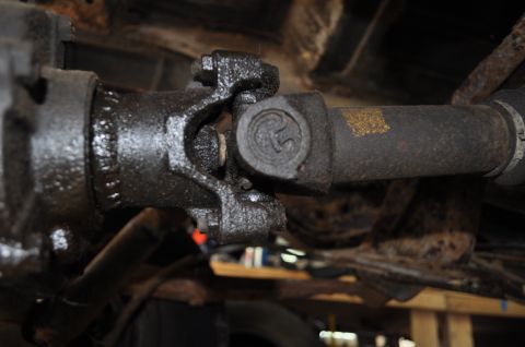 1986 Ford Bronco - Close-up view of a driveshaft universal joint, showing wear and grease. The Supermotors.net logo is visible in the lower right corner.