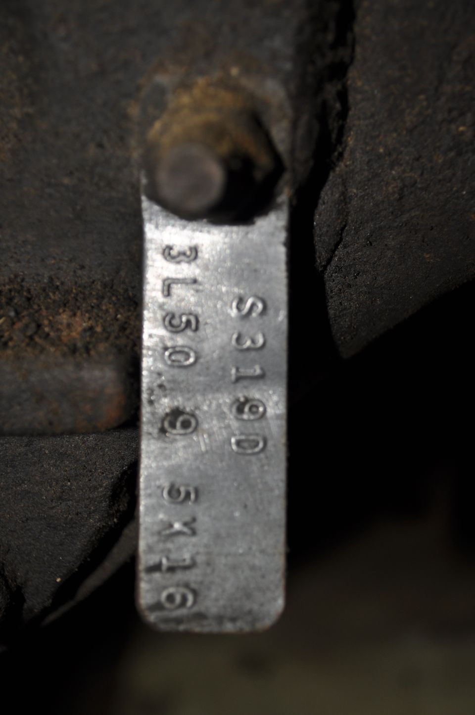 Metal tag stamped with 3L50.9 5X116 and S319D, attached to engine block
