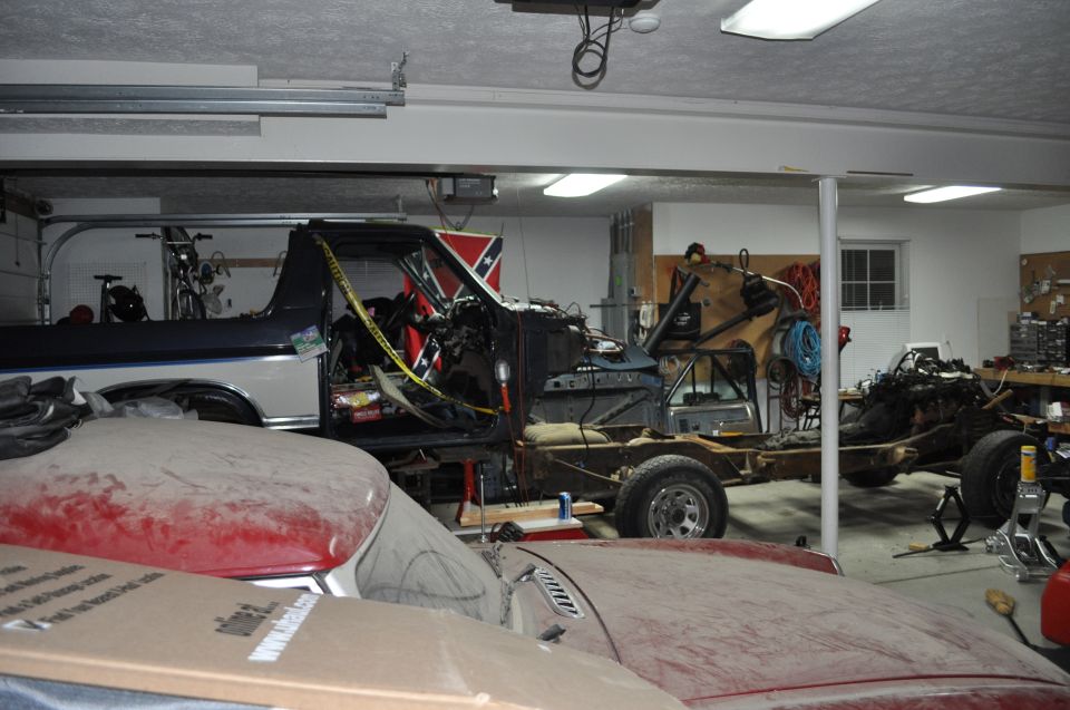 Disassembled truck in garage with Confederate flag visible