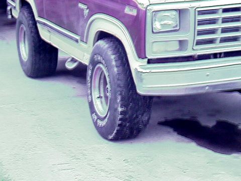 1980 Ford Bronco - Front quarter view of a purple and white 1980 Ford Bronco, highlighting its grille and headlights.
