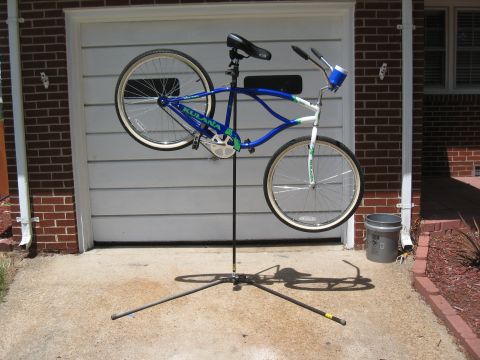 1994 Ford Bronco - A bicycle is mounted on a repair stand before a closed garage door.