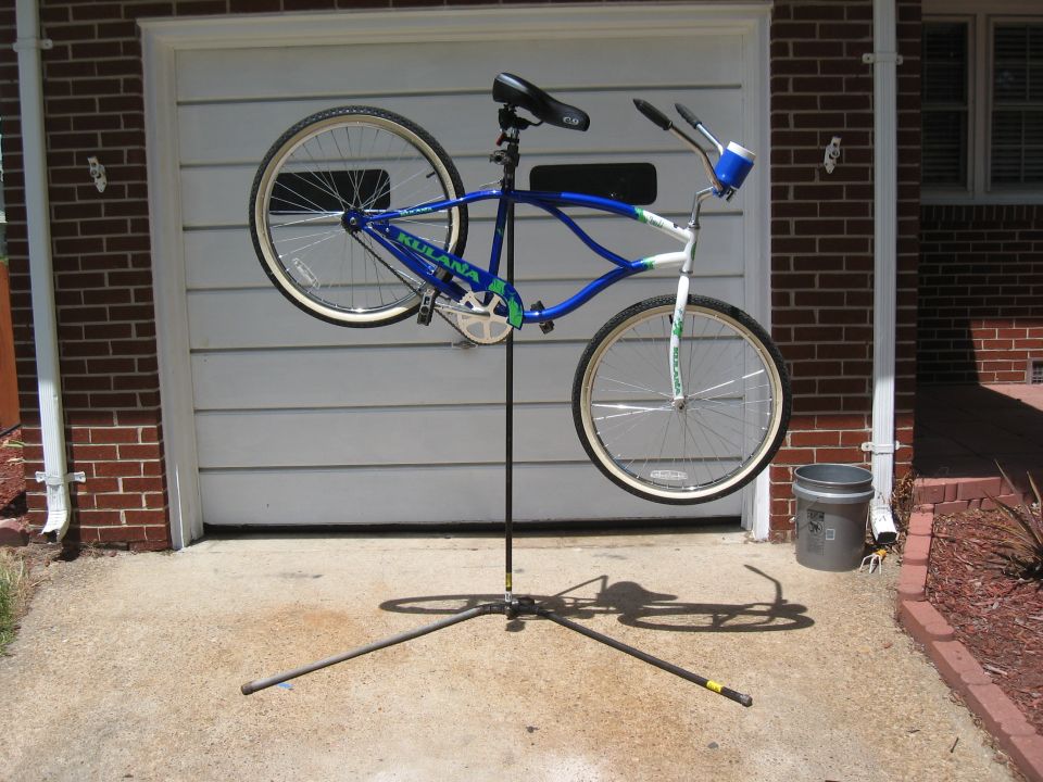 Blue and white bicycle on a stand in front of a garage door