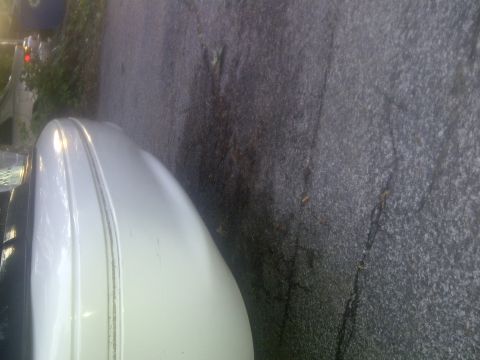 2000 Ford Crown Victoria - Side view of a white 2000 Ford Crown Victoria, focusing on the fender detail.