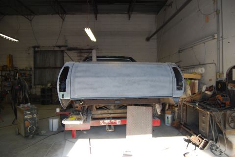 1975 Ford Ranchero - A truck bed with a camper shell is undergoing repairs in a workshop environment.