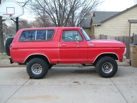 1979 Ford Bronco - Side profile of a red Ford Bronco, showing its body style and spare tire.
