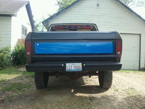 1979 Ford Bronco - The rear of a dark gray 1978 Ford Bronco is visible, a blue panel on the tailgate and an Illinois license plate.