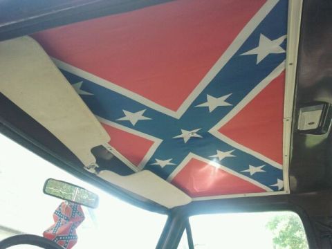 1979 Ford Bronco - The interior of a vehicle features a Confederate flag on the headliner and a matching air freshener.