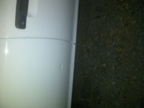 2000 Ford Crown Victoria - Close-up of a white car door handle on a white vehicle.