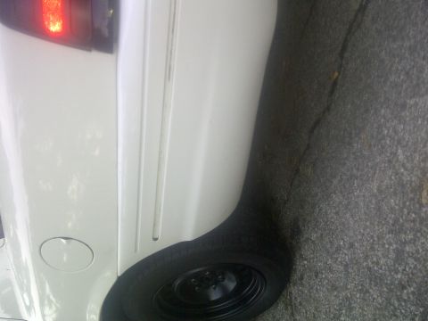 2000 Ford Crown Victoria - The rear of a white sedan is shown, focusing on the tire and body panel.