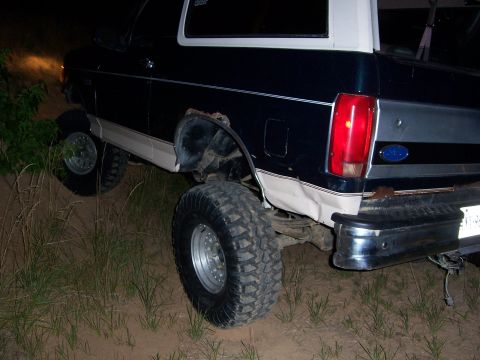 1992 Ford Bronco - This 1992 Ford Bronco is seen off-roading, with its rear end visible on uneven terrain.