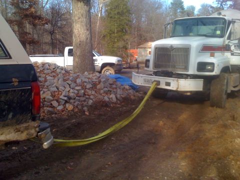 1992 Ford Bronco - A Ford Bronco is being towed by a cement truck using a yellow tow strap.