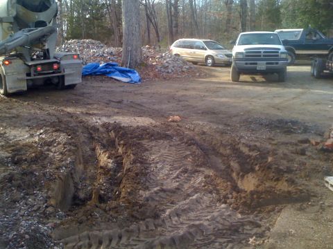1992 Ford Bronco - Multiple vehicles are present at a construction site with a cement truck and tire tracks in the mud.