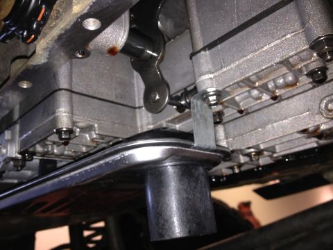 1995 Ford Bronco - Close-up view of a transmission pan and filter clip, showing some fluid leakage.