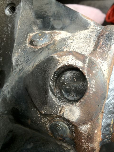 1995 Ford Bronco - This is a close-up view of a heavily weathered and corroded metal automotive part.