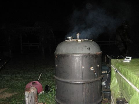1970 Mercury Cougar - Smoker is active and producing smoke at night, with a tarped area and device nearby.