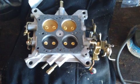1978 Ford Bronco - A carburetor, likely for an older vehicle, is shown resting on a dark cloth surface.