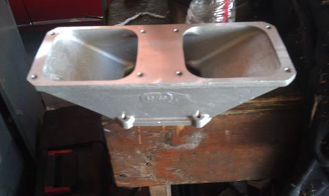 1978 Ford Bronco - An aluminum intake manifold with two openings is shown on a wooden surface.