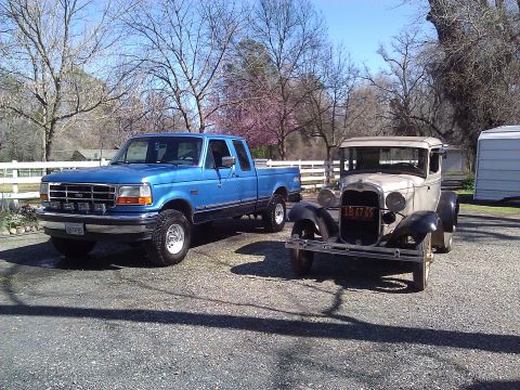 1992 Ford F-150 - A blue 1992 Ford F-150 pickup truck is parked next to a classic beige coupe on a sunny day.