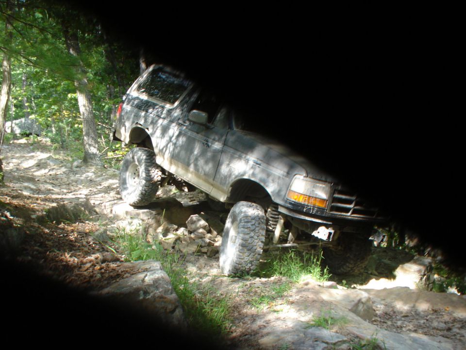Ford Bronco climbing over rocks on a trail