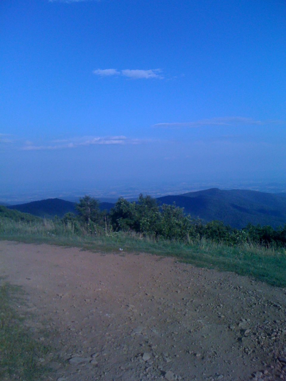 Mountain landscape with dirt road and blue sky