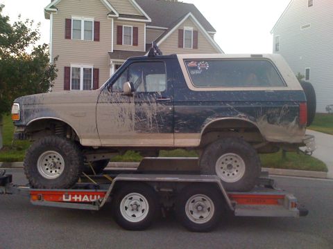 1992 Ford Bronco - A muddy 1992 Ford Bronco is loaded onto a U-Haul trailer.
