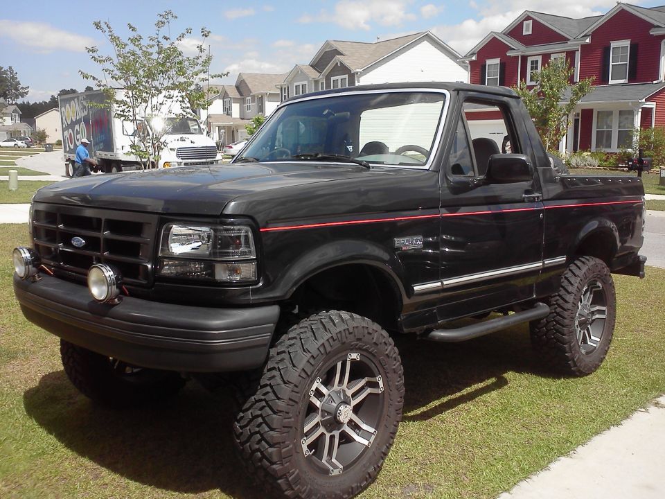 1992 Ford Bronco, black with red pinstripes, lifted with aftermarket wheels