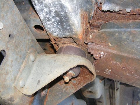 1978 Ford Bronco - Close-up view of heavily rusted frame and suspension components, with a partial '9' visible on the metal.