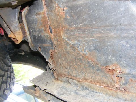 1978 Ford Bronco - Extensive rust and damage are visible on the vehicle's frame rail.