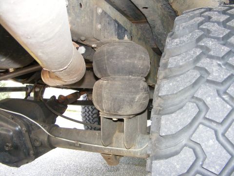 1978 Ford Bronco - Close-up view of a vehicle's air suspension bellows and aggressive tire tread.