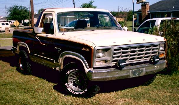 1980s Ford F-Series pickup truck, two-tone paint, aftermarket wheels and lights