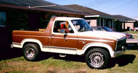 1980 Ford Bronco - This two-tone 1980 Ford Bronco features a removable top and is parked in front of a building.